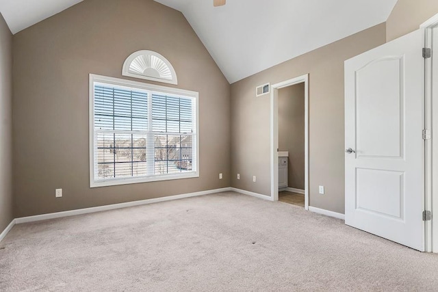 unfurnished bedroom with light carpet, baseboards, visible vents, ensuite bath, and vaulted ceiling