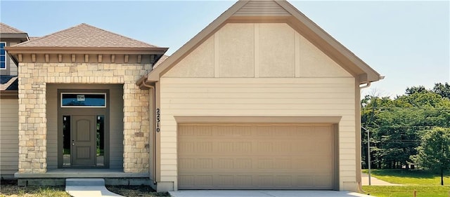 view of front of house featuring driveway, stone siding, an attached garage, and roof with shingles