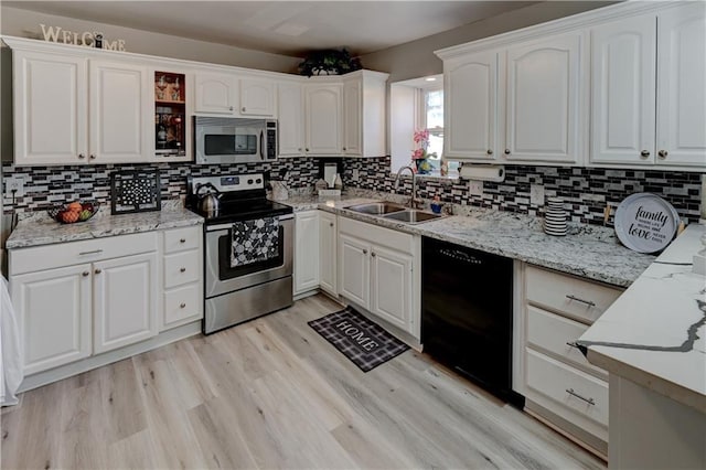 kitchen featuring light wood finished floors, white cabinetry, stainless steel appliances, and a sink