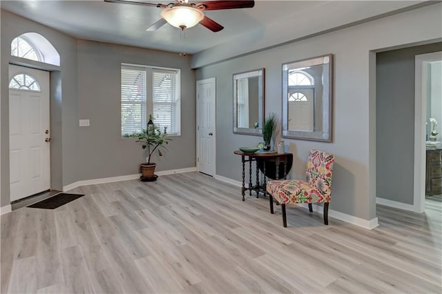 entryway with light wood-style flooring, a ceiling fan, and baseboards