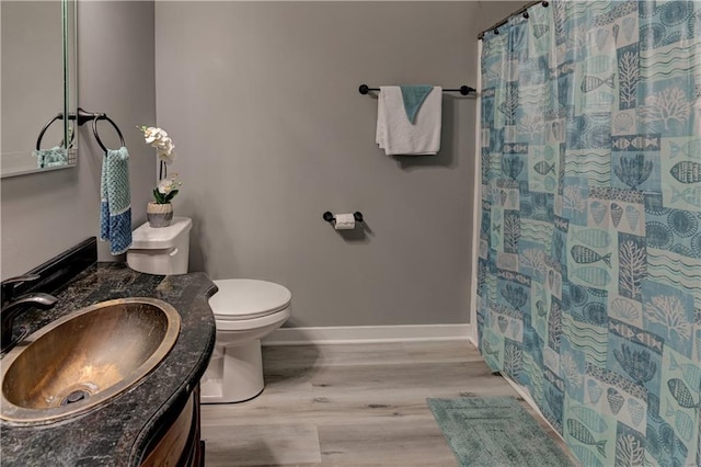 full bathroom featuring toilet, wood finished floors, a shower with shower curtain, baseboards, and vanity