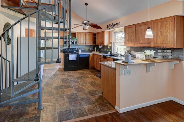 kitchen featuring brown cabinetry, a peninsula, a sink, black appliances, and tasteful backsplash