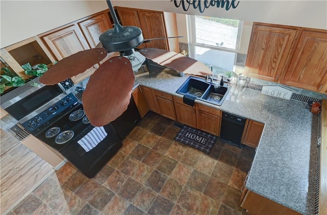 kitchen featuring dishwasher, stainless steel microwave, brown cabinetry, and a sink