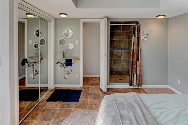 full bath with baseboards and a tile shower