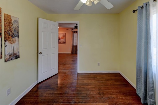 spare room featuring ceiling fan, baseboards, and wood finished floors