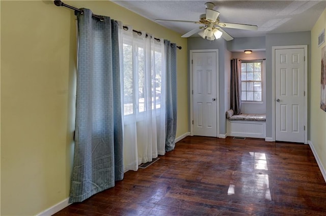 interior space with visible vents, ceiling fan, baseboards, wood finished floors, and a textured ceiling