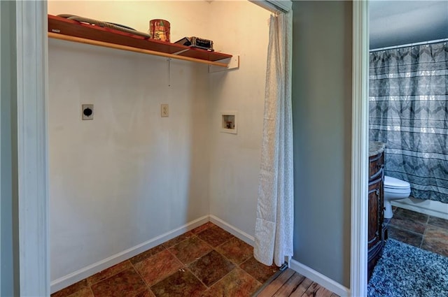 laundry area with electric dryer hookup, stone finish floor, baseboards, hookup for a washing machine, and laundry area