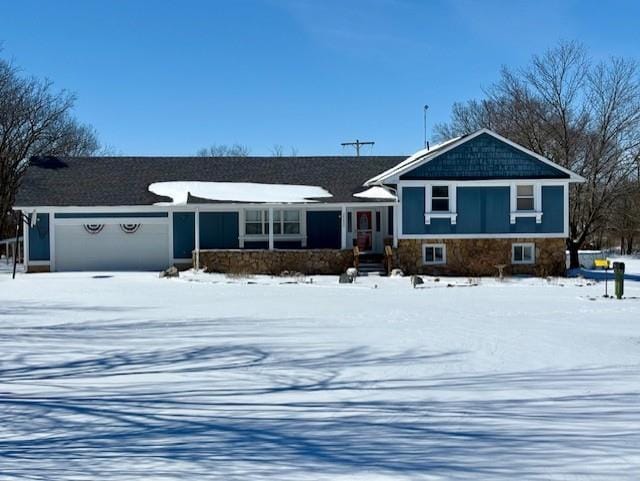 tri-level home with stone siding and an attached garage