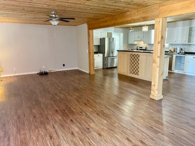 unfurnished living room featuring ceiling fan, wooden ceiling, and wood finished floors