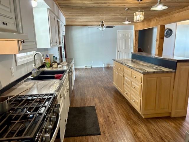 kitchen featuring a center island, hanging light fixtures, a sink, wooden ceiling, and stainless steel gas range oven