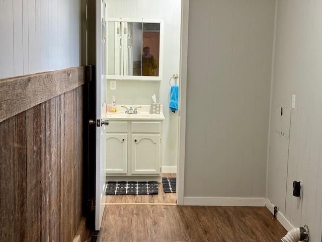 bathroom with baseboards, wood finished floors, and vanity