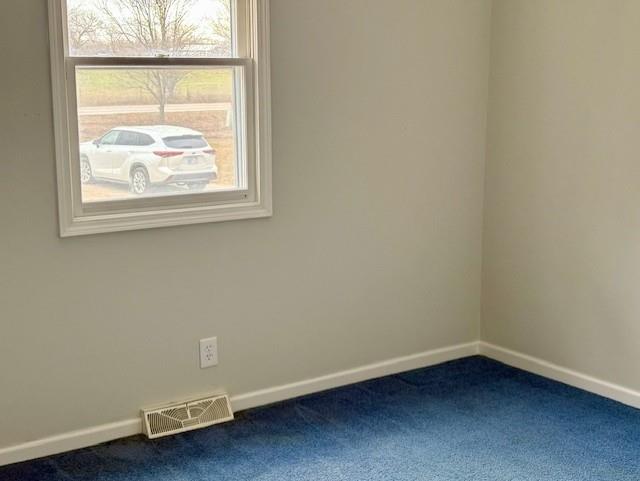 unfurnished room featuring carpet floors, visible vents, and baseboards