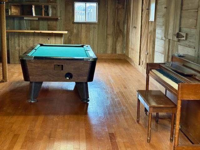 playroom featuring wooden walls, wood finished floors, and pool table