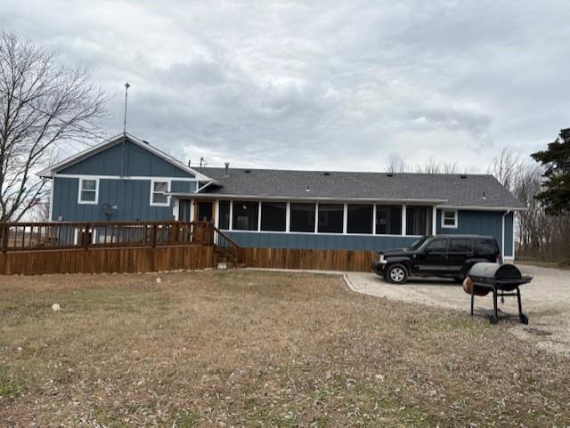 rear view of property featuring a lawn