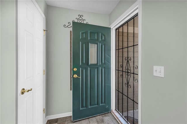 foyer entrance featuring wood finished floors and baseboards