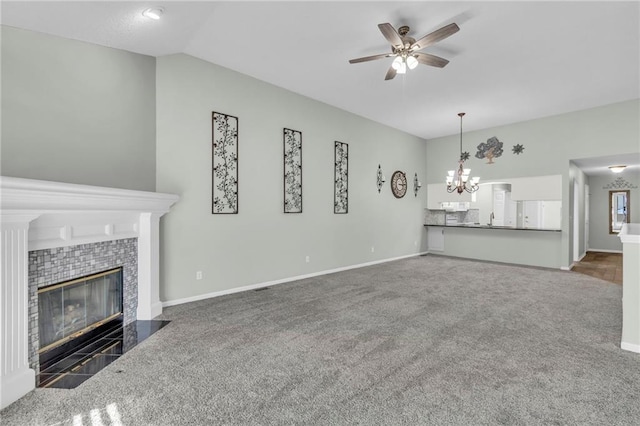 unfurnished living room with a fireplace, dark colored carpet, lofted ceiling, baseboards, and ceiling fan with notable chandelier