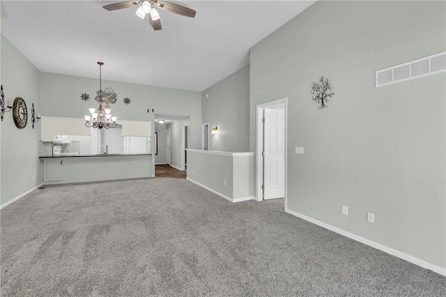 unfurnished living room featuring carpet, visible vents, baseboards, and ceiling fan with notable chandelier