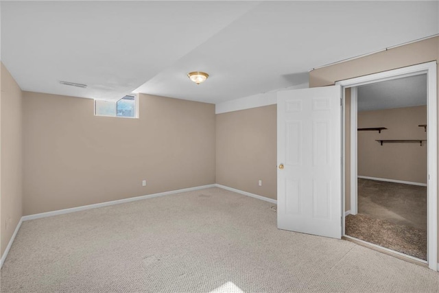 basement featuring light carpet, visible vents, and baseboards