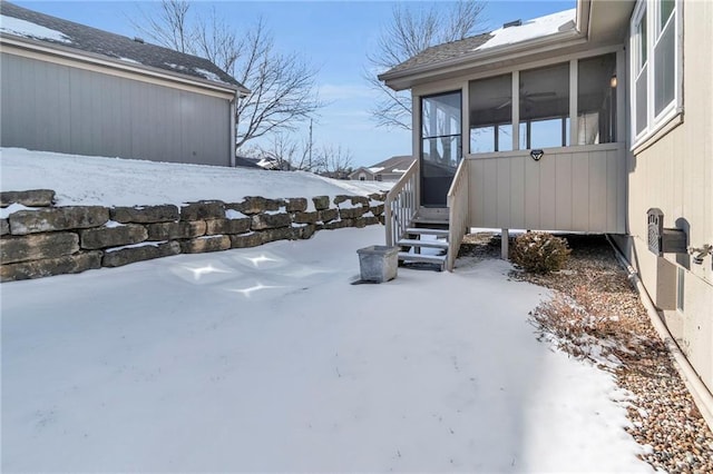 yard layered in snow with a sunroom