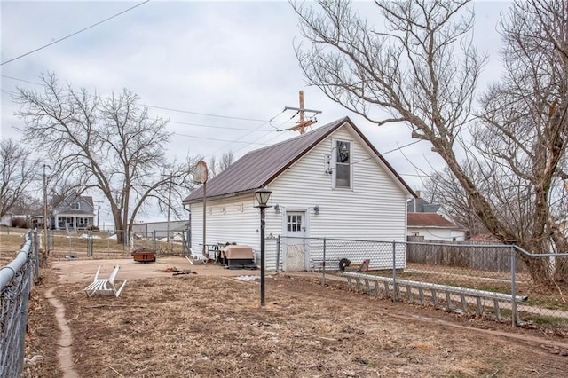 view of side of property featuring metal roof, a patio, and a fenced backyard