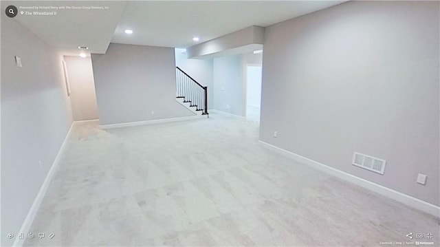 finished basement featuring recessed lighting, light colored carpet, visible vents, baseboards, and stairs