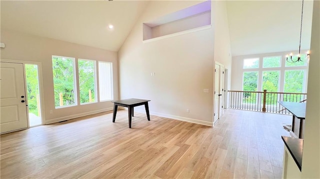 22312 W 76th St, Shawnee, KS 66227 - entryway with high vaulted ceiling, a chandelier, plenty of natural light, and light wood-style flooring