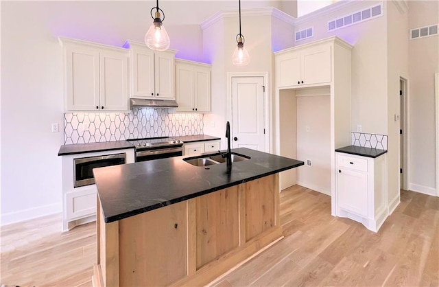 22312 W 76th St, Shawnee, KS 66227 - kitchen featuring appliances with stainless steel finishes, under cabinet range hood, dark countertops, tasteful backsplash, and ornamental molding