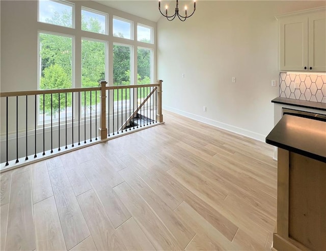 22312 W 76th St, Shawnee, KS 66227 - spare room featuring a chandelier and light wood-style flooring