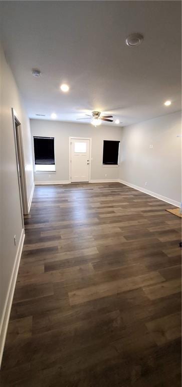 spare room with dark wood-type flooring, recessed lighting, and baseboards