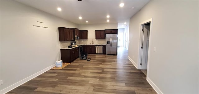 kitchen featuring stainless steel appliances, dark wood-style flooring, baseboards, dark brown cabinets, and light countertops