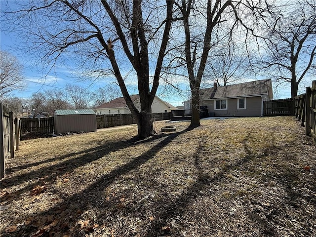 view of yard with an outbuilding, a storage unit, and a fenced backyard