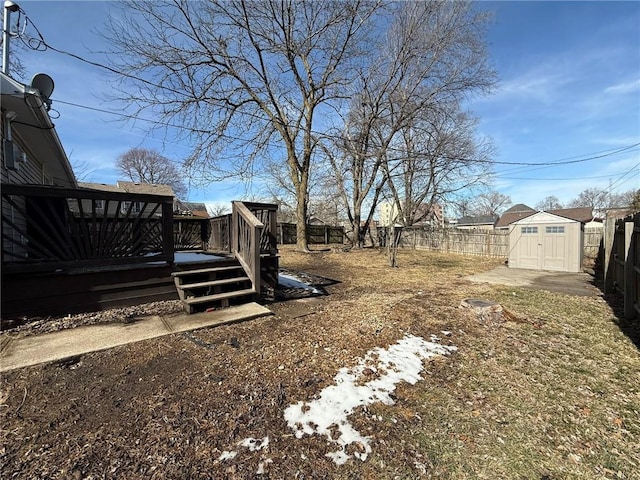 view of yard with a deck, a shed, an outdoor structure, and a fenced backyard