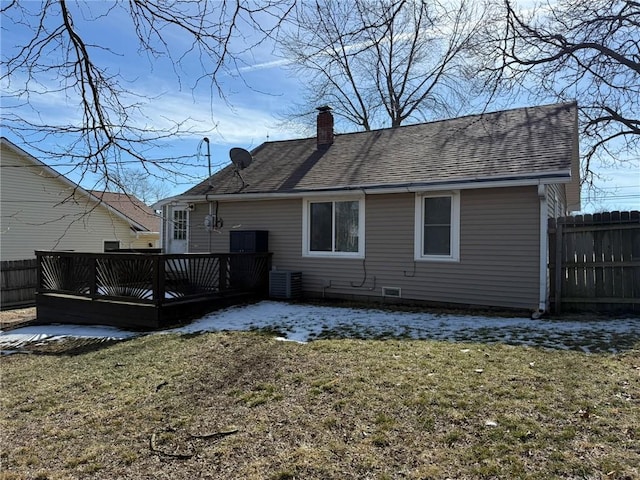 back of house featuring a shingled roof, fence, a yard, a wooden deck, and a chimney