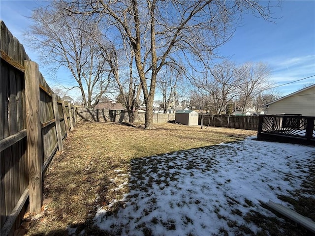 yard covered in snow with a fenced backyard, a shed, and an outdoor structure