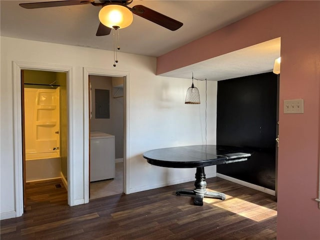 dining space featuring baseboards, electric panel, washer / clothes dryer, and wood finished floors