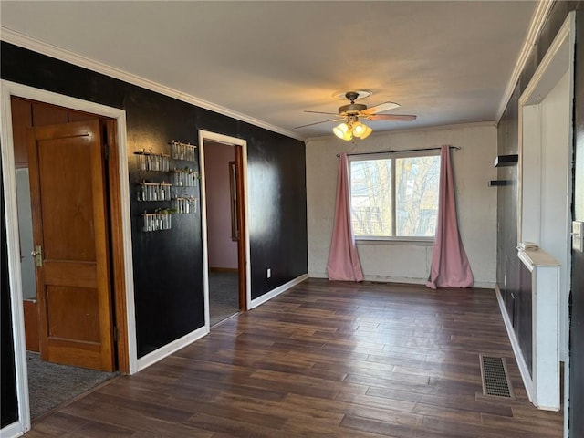 unfurnished bedroom featuring baseboards, visible vents, ceiling fan, ornamental molding, and dark wood-type flooring