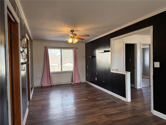 empty room with baseboards, a ceiling fan, dark wood finished floors, and crown molding