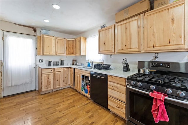 kitchen featuring stainless steel gas range, black dishwasher, a sink, and light brown cabinetry