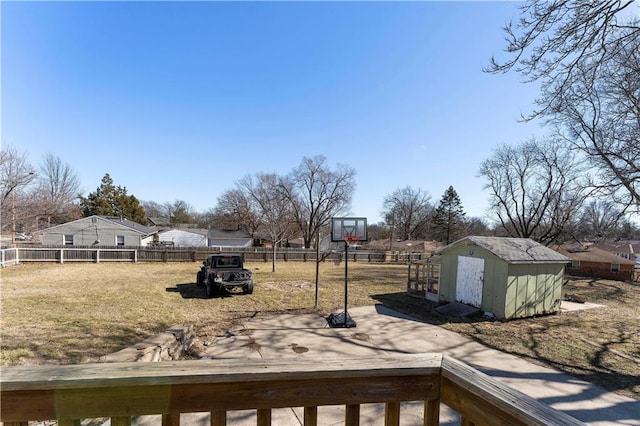 view of yard featuring an outbuilding, a fenced backyard, and a storage shed