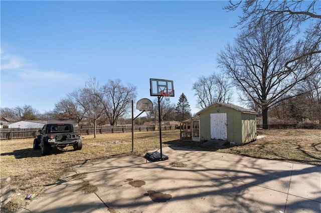 exterior space featuring an outbuilding, fence, and basketball court