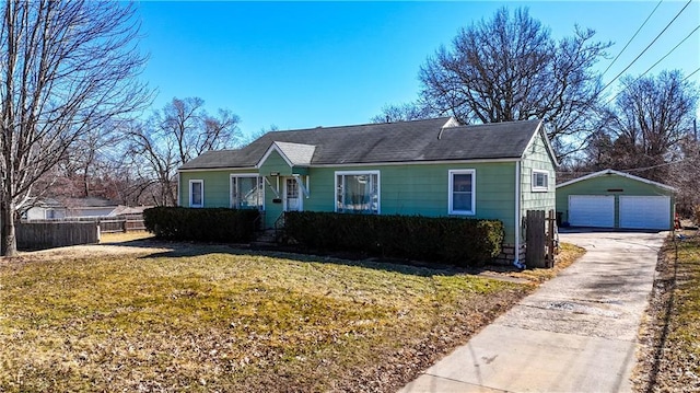 view of front of house featuring a garage, a front yard, fence, and an outdoor structure