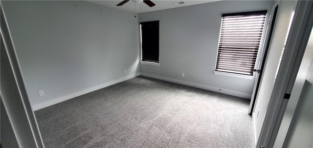 carpeted empty room with a ceiling fan, visible vents, and baseboards