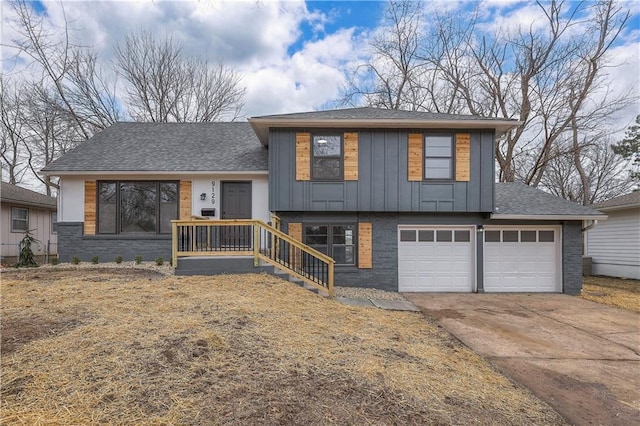 split level home featuring an attached garage, brick siding, driveway, roof with shingles, and board and batten siding