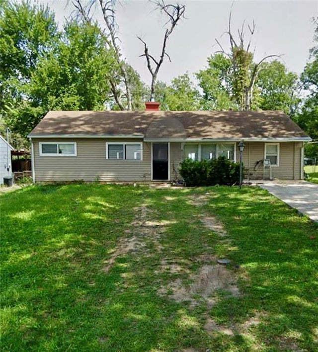 single story home with a front yard and a chimney