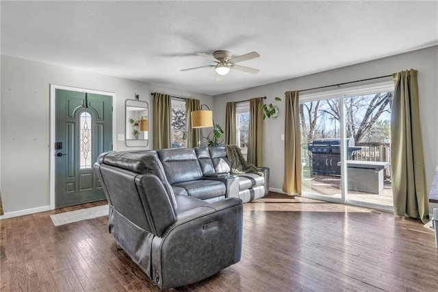 living room featuring a ceiling fan, baseboards, and hardwood / wood-style floors