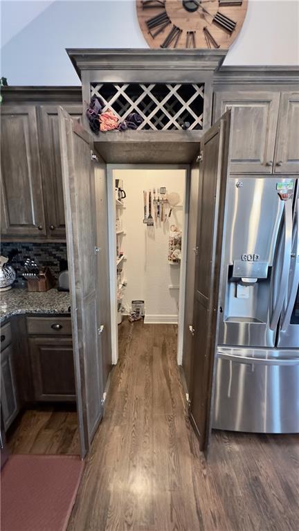 kitchen featuring dark wood-style floors, dark brown cabinetry, and stainless steel refrigerator with ice dispenser