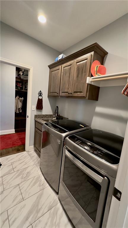 clothes washing area with cabinet space, washing machine and clothes dryer, marble finish floor, a sink, and recessed lighting