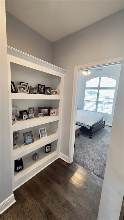 corridor with baseboards and dark wood finished floors