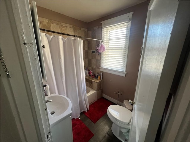 full bath with toilet, baseboards, and shower / bath combination with curtain