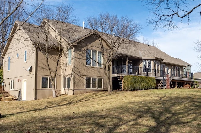 rear view of house featuring a lawn, a wooden deck, and stucco siding